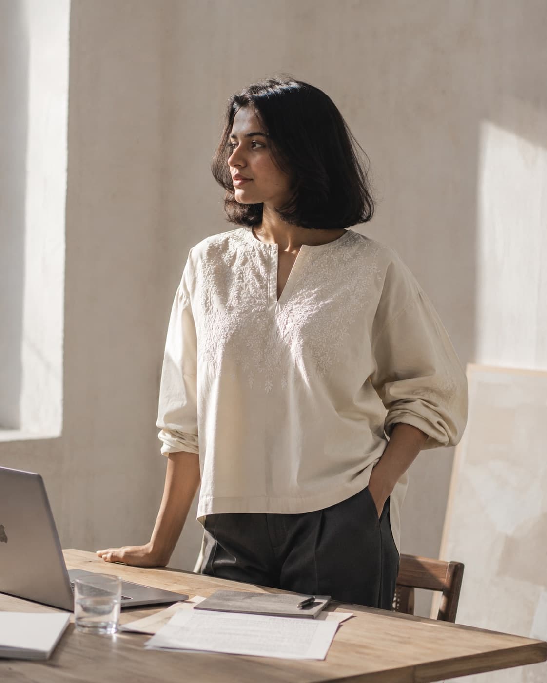 Woman wearing the chikankari co-ord kurta separately over tailored trousers at a desk